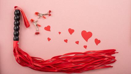 Red whip, nipple clamps, hearts on a pink background. Valentine's day greeting card