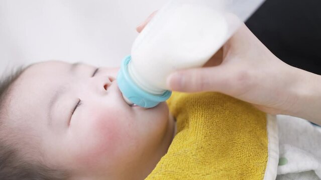 寝ながらミルクを飲むアジア人の赤ちゃん