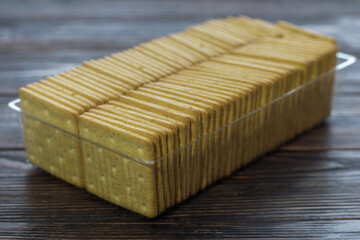 Crackers in plastic packaging on a wooden dark background