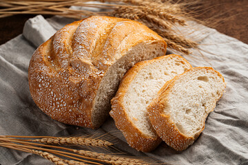 Freshly baked sliced loaf of creamy bread on napkin 