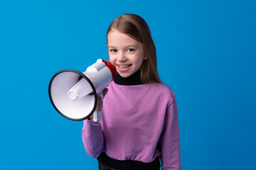 Child girl using megaphone against blue background