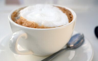 Close-up white frothed milk on cappuccino or latte coffee. Hot coffee  ready-to-drink in the morning.