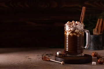 hot black coffee with cinnamon, anise and marshmallows in a glass mug
