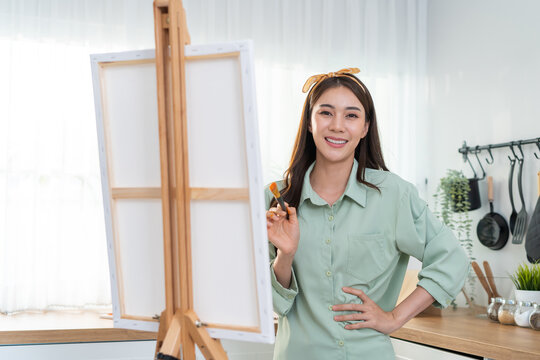 Portrait of Asian young artist girl coloring on painting board at home
