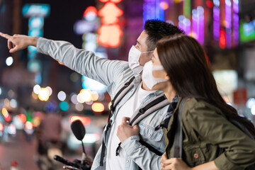 Asian young couple wear mask while travel in city for honeymoon trip