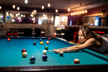 attractive woman hold cue and playing billiards