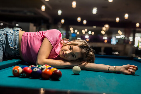 woman in black dress near balls lying on snooker table