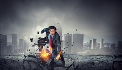 Determined businessman leaving fire trails on asphalt . Mixed media