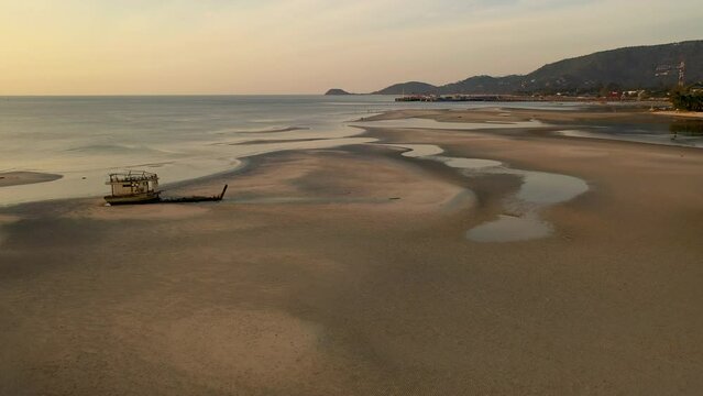 Sunset scenes of boat wreck along shore side - boat wreck stranded on sand bank - Nathon harbour - Koh Samu Island in Thailand