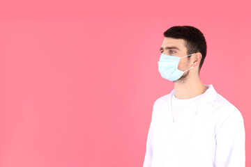Doctor - intern in mask on pink background