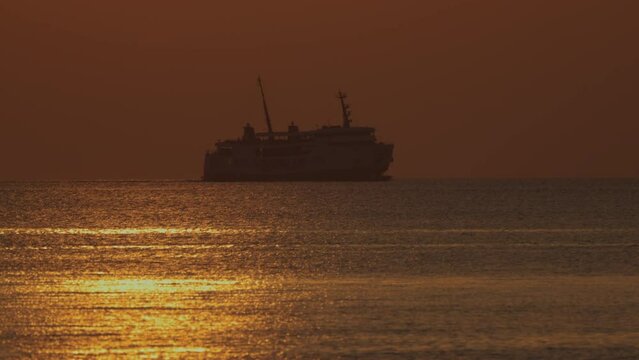 Sunset scene of ferry boat in silhouette on the horizon - Nathon harbour - Koh Samu Island in Thailand