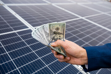 beautiful young gorgeous worker hands holding round sum of money for installing solar panels.