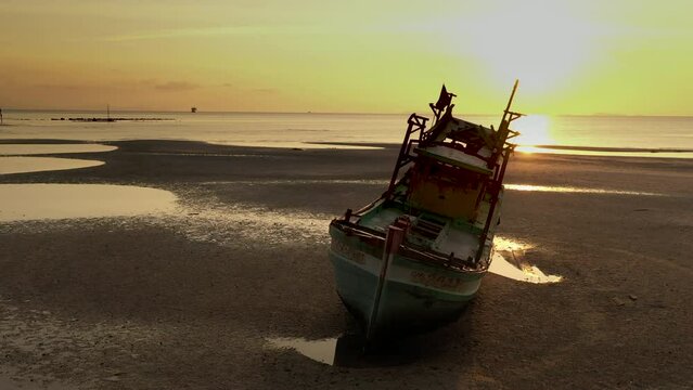 Sunset scenes of boat wreck along shore side - close fly pass by of boat hull - Nathon harbour - Koh Samu Island in Thailand