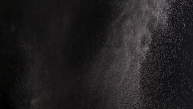 Slow motion. Spraying water droplets. Water spray nozzle. Water vapor jet from the humidifier. White smoke isolated on black background with visible droplets. Isolated