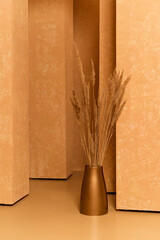 Orange minimalist home decor background. Dried plants in a vase and textured walls