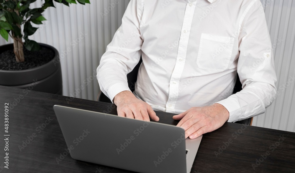 Poster Man hands typing on laptop. Businessman sitting at desk in office. Working online and using computer technology in work concept. High quality photo