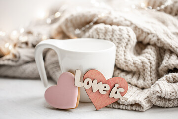 Cozy composition for Valentine's Day with a cup and decor details.