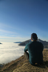 Naklejka na ściany i meble Traveler hiking in mountains clouds landscape