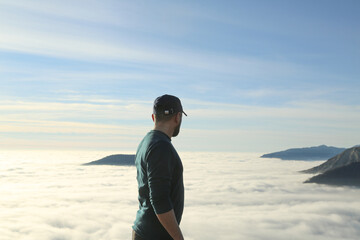 Traveler hiking in mountains clouds landscape