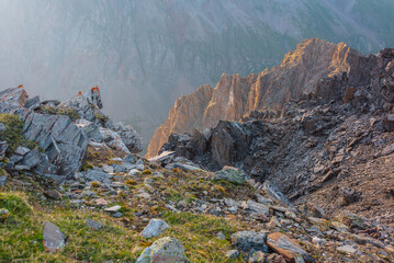 Awesome mountain view from cliff at very high altitude. Scenic landscape with beautiful sharp rocks near precipice and couloirs in sunlight. Beautiful mountain scenery on abyss edge with sharp stones.