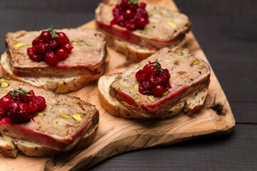 Sliced Traditional French terrine covered with bacon on dark wooden background