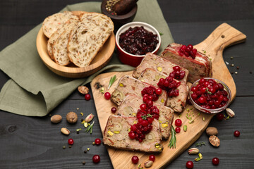 Sliced Traditional French terrine covered with bacon on dark wooden background