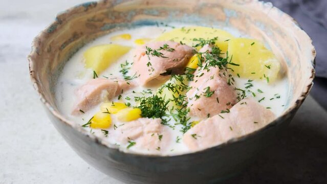 Norwegian fish soup with trout, potatoes and corn, gray background. Salmon and potato chowder.