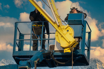 Assemblers repairing a harbor crane on a high lift
