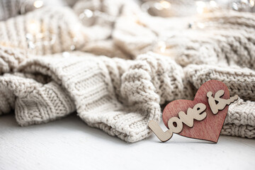 Fototapeta na wymiar A decorative heart among cozy knitted items. Valentine's Day holiday concept.