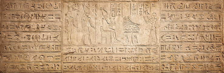 Old Egyptian hieroglyphs on an ancient background. Wide historical background. Ancient Egyptian hieroglyphs as a symbol of the history of the Earth. - obrazy, fototapety, plakaty