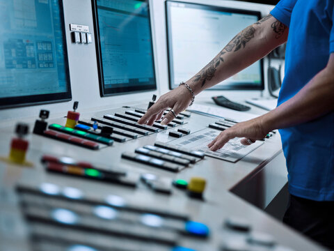 Woman operating CNC machine at industry