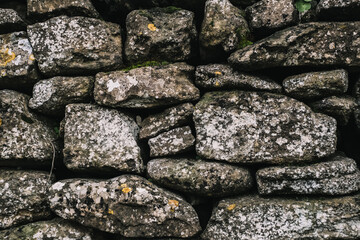 Background of a stone wall closeup. Texture of large and small multi-colored stones in concrete.