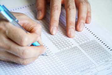 Students hold a pencil and write their choice on the answer sheet and math question sheet. college entrance examination students