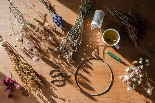 Studio shot of scissors, wire, thread and various dried flowers ready to be weaved into wreath