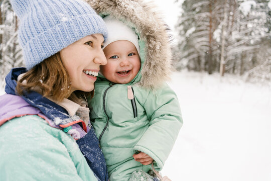 Contemplative woman with cute daughter in winter