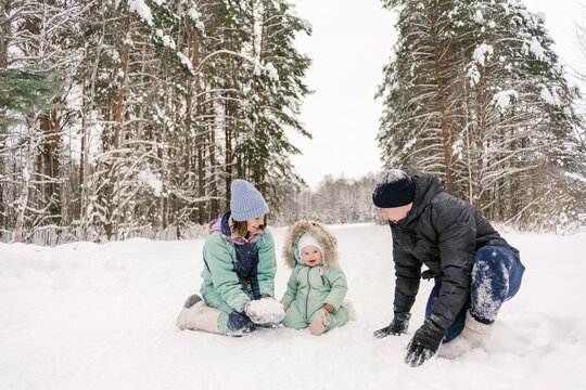 Happy family playing with snow in winter