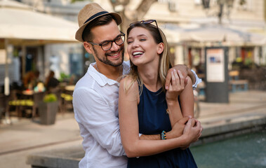 Holidays, vacation, love and friendship concept. Smiling couple having fun together in city