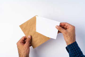 Top view of male hands hold (open) an envelope above white background