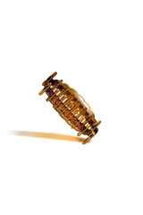 Subject shot of an amber colored hair clip with a curly edge. The hair clip is isolated on the white background. Vogue accessory for ladies and girls.