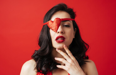 Beautiful woman dressing in red with heart shaped eye patch