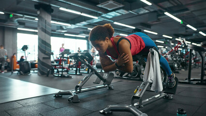 Fototapeta na wymiar Black girl doing sport exercise for lumbar in gym