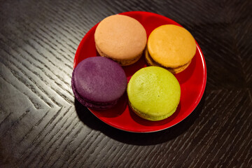 Sweet biscuits in soft focus on a red saucer.