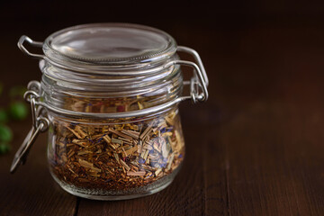 Jar of loose tea leaves on a wooden brown table