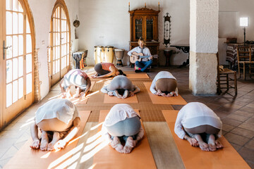 Musician playing in front of people exercising in yoga studio