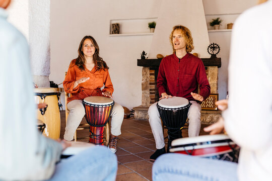 Multiracial friends playing bongo in classroom