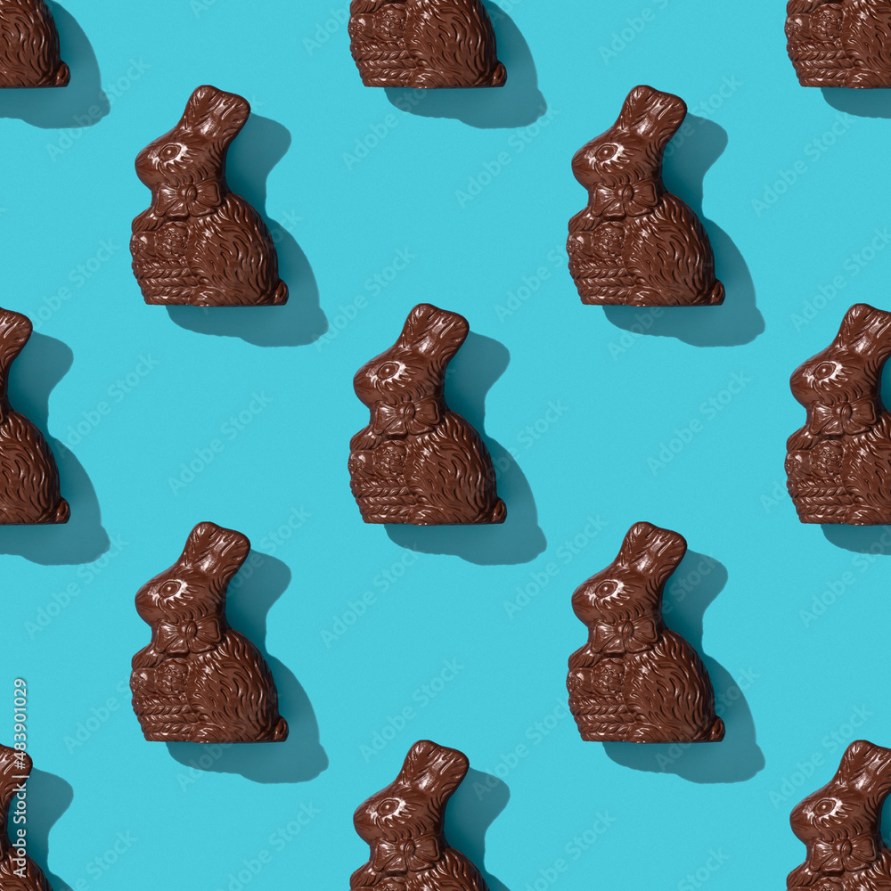 Wall mural chocolate easter bunny on blue background pattern, flat lay