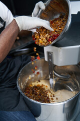 Man adding berries to the dough for baking