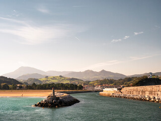 Groyne and lighthouse by beach at Basque Coast Geopark, Basque Country, Spain