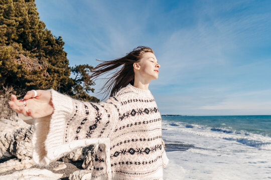 Teenage girl with eyes closed enjoying breeze at beach