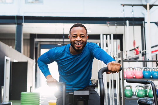 Athlete with gap teeth exercising on airbike in gym